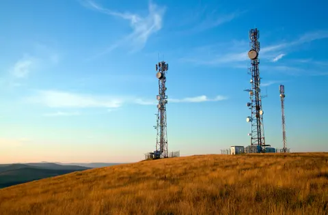 Pylônes de téléphonie mobile au sommet d'une colline, au lever du jour